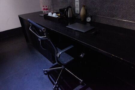 office space with laptop and clock and tea making setの写真素材