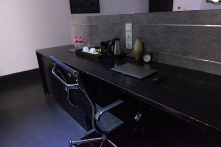 office space with laptop and clock and tea making setの写真素材