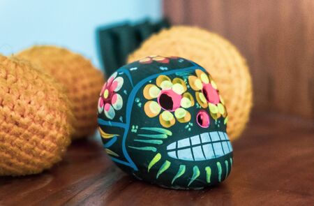 Mexican style small skull head figure on a wooden shelfの写真素材
