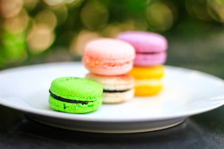 A batch of coloroful French macaroons on a table and Coffee, cappuccinoの写真素材
