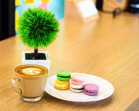A batch of coloroful French macaroons on a table and Coffee, cappuccinoの写真素材