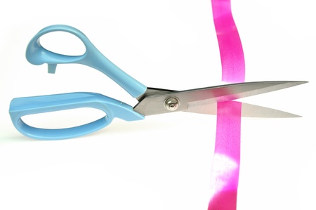 Cutting pink ribbon isolated on white