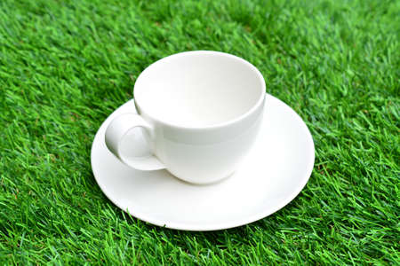 Cup of coffee on green grassの写真素材