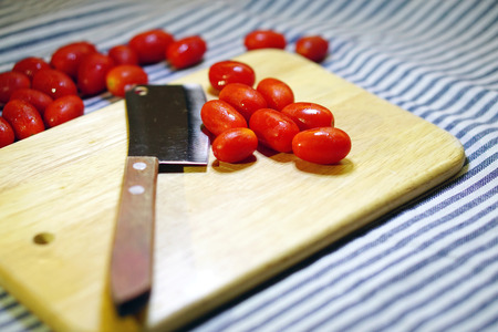 Red cherry tomatoes on a wooden boardの写真素材