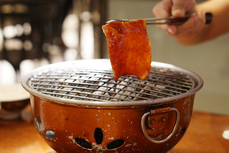 Grilling Raw Sliced Kurobuta Pork over Hot Charcoal Stove, Japanese Barbecue Style called Yakiniku.の写真素材