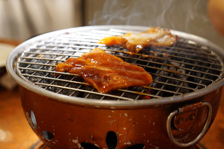 Grilling Raw Sliced Kurobuta Pork over Hot Charcoal Stove, Japanese Barbecue Style called Yakiniku.の写真素材