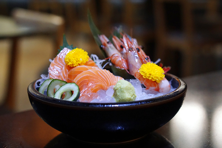 Closeup Bowl of Mixed Seafood Sashimi Set Raw Food Japanese Style, Fresh Salmon and Fresh Amaebi (Sweet Shrimp) served with wasabi and zucchini on Ice, Selective focus.の写真素材