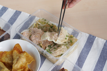 Dried egg noodle with dumplings pork soup, served with marinated pork chop, Traditional Thai food recipe, Popular street food of Thailand.の写真素材