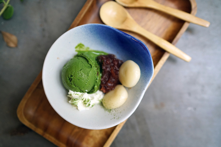 A bowl of homemade matcha ice cream (green tea latte ) served with red bean and mochi. Traditional Japanese dessert.の写真素材