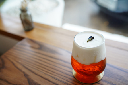A glass of iced oolong tea (wulong or wu long) with layer of cream cheese foam on blurred background, Traditional Chinese and Taiwanese Beverage.の写真素材