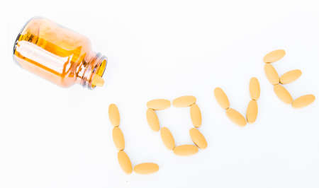 Yellow pins on white background, sign LOVEの写真素材