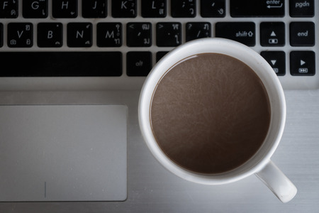Coffee cup put on laptopの写真素材