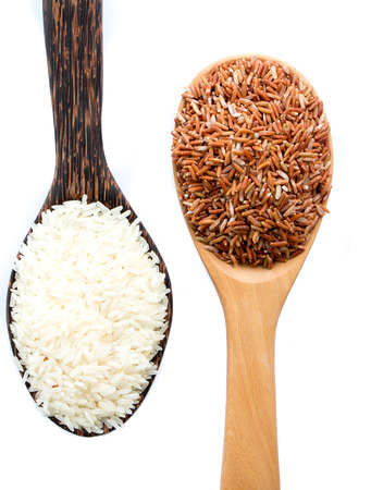 brown rice and white rice on wooden spoon isolate on white background.の写真素材