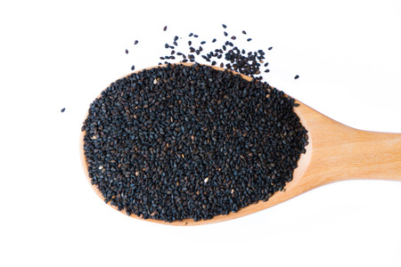 Black sesame put on wooden spoon isolated on white background.の写真素材