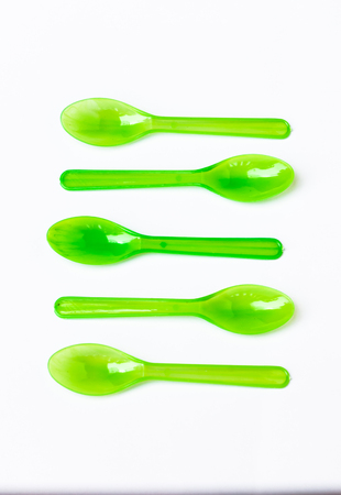 Green plastic spoon on white backgroundの写真素材