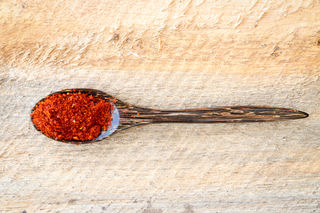 red pepper in wooden spoon put on wooden tableの写真素材