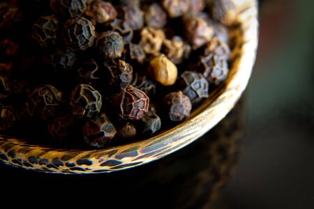 Black pepper in wooden spoonの写真素材