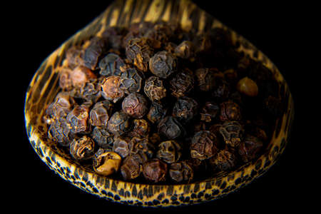 Black pepper in wooden spoonの写真素材