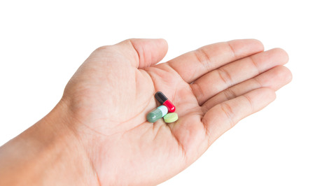pill in male hand on white background isolatedの写真素材