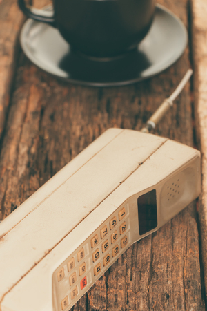 vintage mobile phone with cup of coffee vintage styleの写真素材