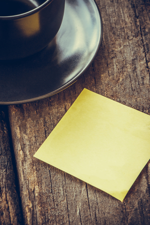 cup of coffee with yellow paper note on wooden backgroundの写真素材