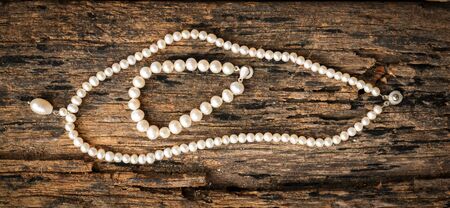 White pearl put on old wooden table.の写真素材