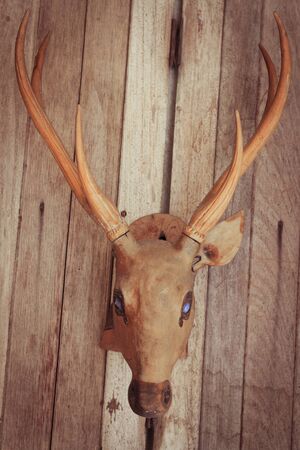 Brown deer head realistic on brown wood wallの写真素材