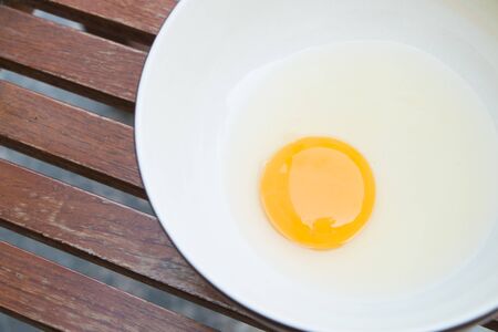 raw egg yolk on the dish on tableの写真素材