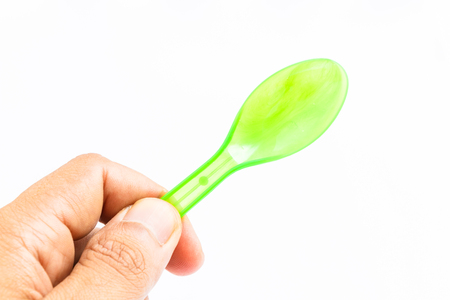 Green plastic spoon on white backgroundの写真素材