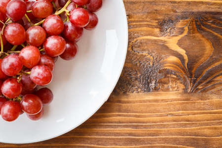 Red grape on wooden table, Healthy concept.の写真素材