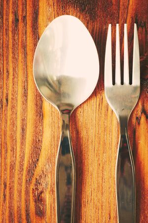 Metal spoon and fork put on wooden tableの写真素材