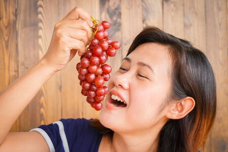 Young woman showing grapes in her hand, Healthy concept.の写真素材