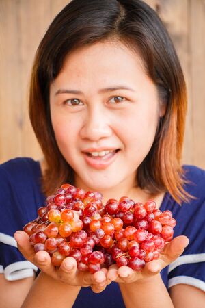 Young woman showing grapes in her hand, Healthy concept.の写真素材
