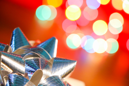 bow with gift box on defocused colorful bokeh light backgroundの写真素材