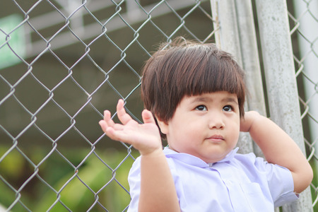 cute kid with fenceの写真素材