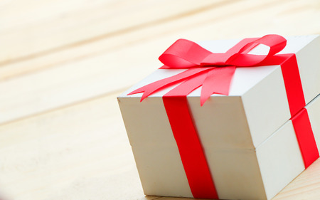 Red bow gift on wooden table