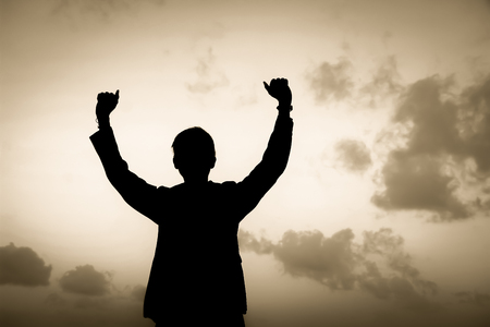 Silhouette of man showing his hand on soft sky background, Successful business concept.の写真素材