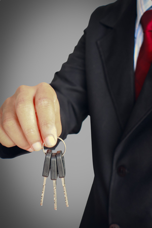 Businessman with red tile holding keyの写真素材