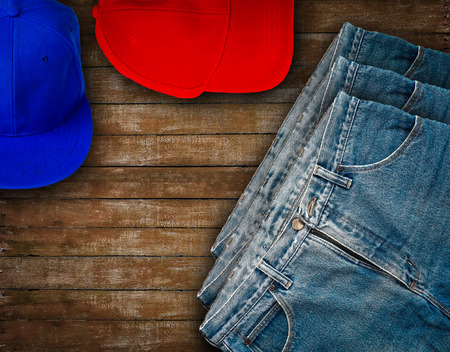 Jeans put on wooden table with baseball capの写真素材