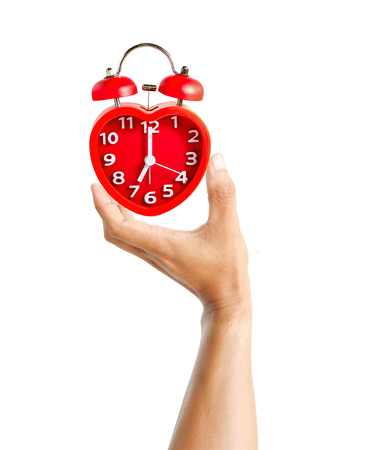 Male hand holding red clock mark at 7 o'clock mean wake up time to work concept isolated on white backgroundの写真素材