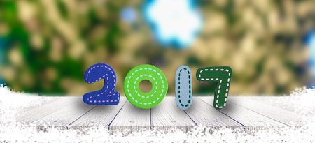 New years 2017 sign on wooden tabletop and snow fresh green leaves gift.の写真素材