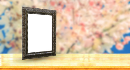 old picture frame put on tabletop with blurred sakura flowers background use for picture displayの写真素材