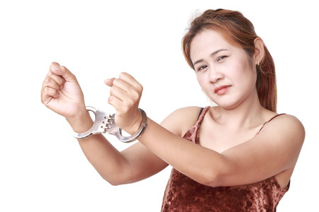 Beautiful young girl with handcuffs isolated on white backgroundの写真素材