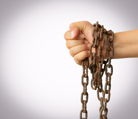 Man's hands tied with chains isolated on white background