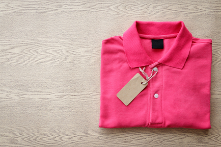 Close up top view of man polo shirt put on rustic wooden table top with blank space use for texts displayの写真素材