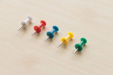Colorful pin put on wooden table top background