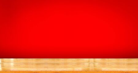 wooden table top with color red background use for products show or displayの写真素材