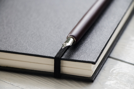 fountain nib pen with black leather book put on wooden with space use for texts or products displayの写真素材