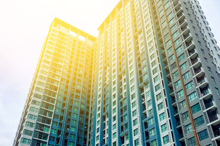 Blurred image of building with blue sky and sun flare backgroundの写真素材