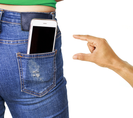 Thief hand trying to stole mobile phone in woman pocket jeansの写真素材
